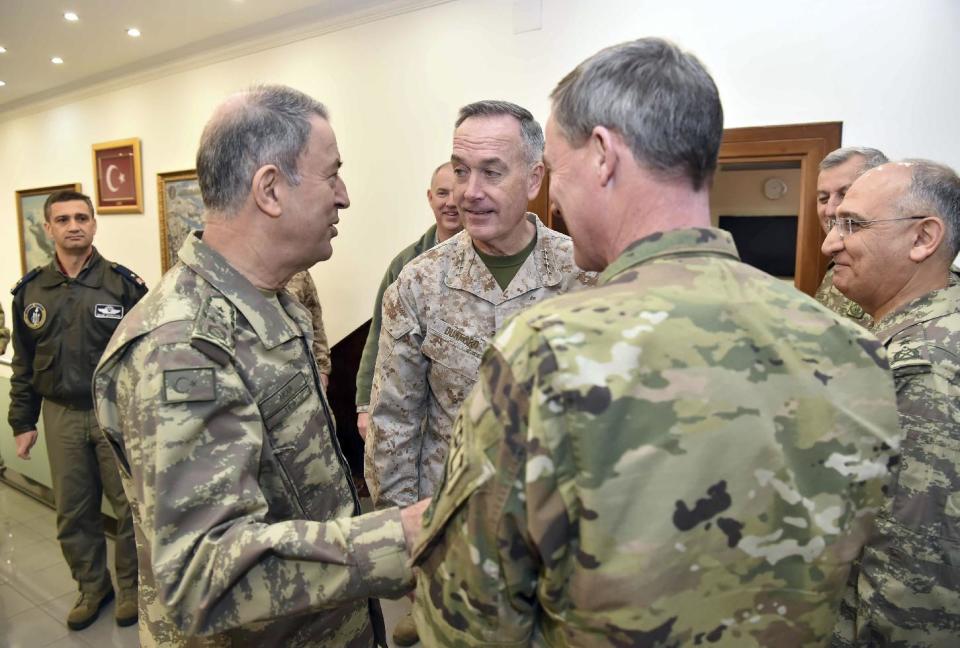 The U.S. chairman of the Joint Chiefs of Staff, Gen. Joseph Dunford, rear centre, and Turkey's Chief of Staff Gen. Hulusi Akar, left, talk during a meeting in Incirlik Airbase in Adana, Turkey, Friday, Feb. 17, 2017. Turkey's military says the Turkish and U.S. chiefs of staff have "confirmed" the need to fight terror groups in Syria and Iraq, including the Islamic State group and Kurdish militants.(Turkish Military, Pool Photo via AP)