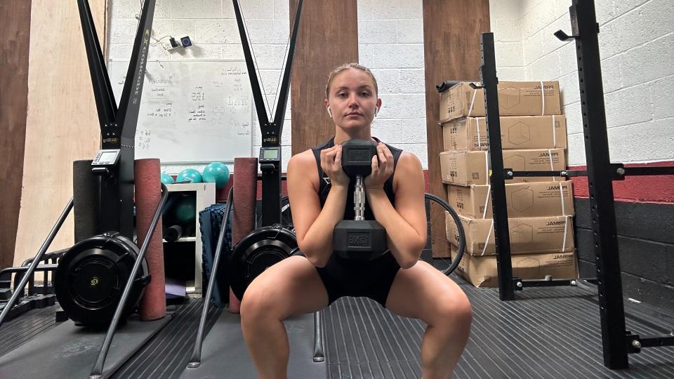 Woman doing a goblet squat with a dumbbell