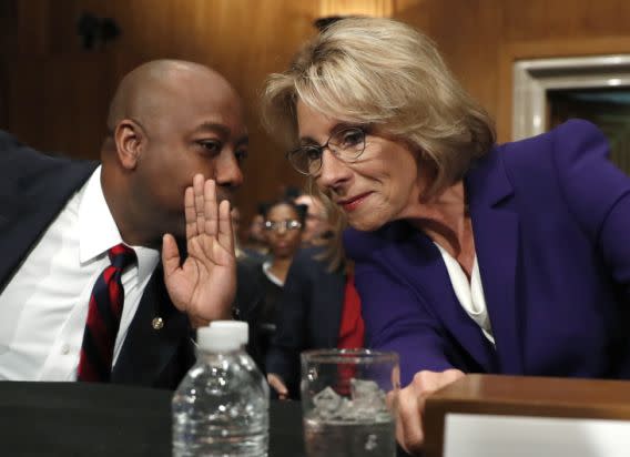 Education Secretary-designate Betsy DeVos talks to Sen. Tim Scott, R-S.C., before testifying on Capitol Hill in Washington, Tuesday, Jan. 17, 2017, at her confirmation hearing before the Senate Health, Education, Labor and Pensions Committee. Scott was to introduce her to the committee. (AP Photo/Carolyn Kaster)