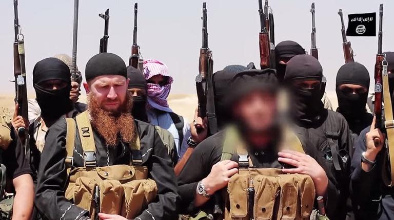 An image released by jihadist outlet al-Itisam Media on June 29, 2014, is said to show Islamic State members including Abu Mohammed al-Adnani (R), whose picture was blurred by the source to protect his identity, speaking at an unknown location