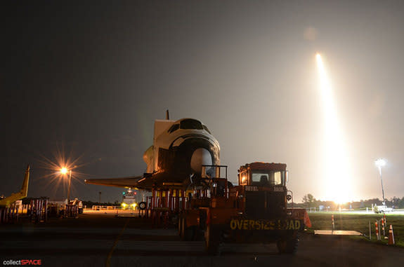 SpaceX's first space station-bound Dragon spacecraft, flying atop a Falcon 9 rocket, launches behind a high fidelity mockup of the space shuttle, NASA's previous means of delivering cargo to International Space Station. Liftoff occurred on May