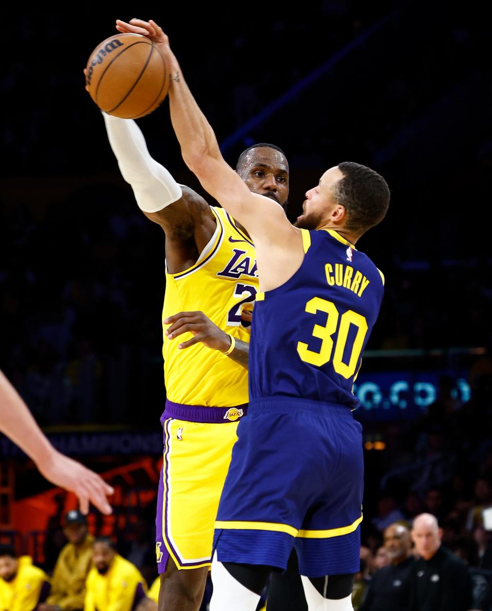 LeBron James #23 of the Los Angeles Lakers passes the ball against Stephen Curry #30 of the Golden State Warriors in the first half at Crypto.com Arena on April 09, 2024 in Los Angeles, California.