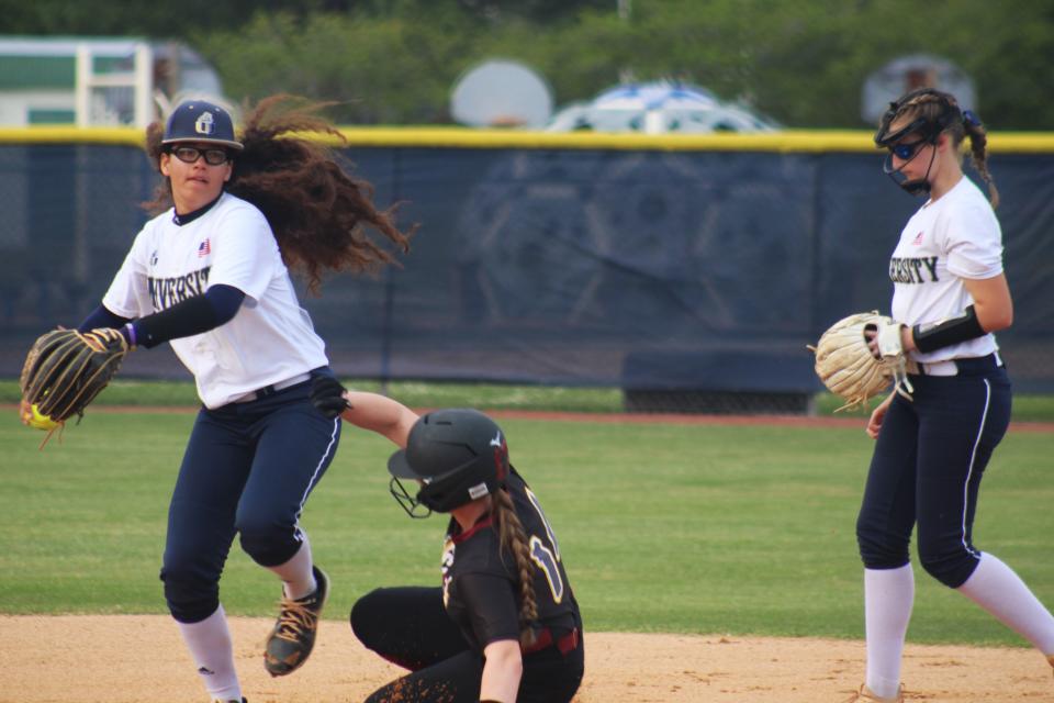 University Christian shortstop Elissa Murdock turns a double play as West Nassau's Teagan Harter slides into second base in an April 2 game.