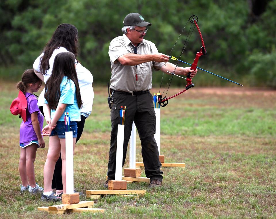 Jonathan Rogers demonstrates how to use a bow and arrow at Abilene State Park June 1. The park celebrated its 90th birthday with games and activities.