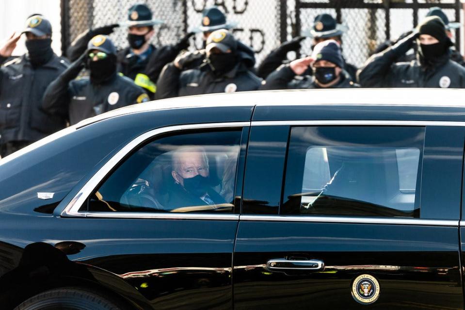 President Joe Biden looks out the window of the Presidential limousin