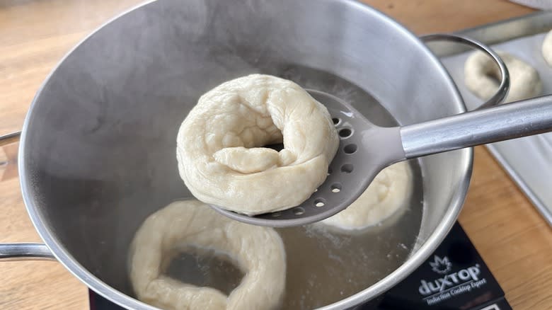 Lifting bagel out of simmering soda bath
