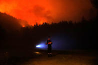 A firefighter looks at a wildfire burning near the village of Metochi, north of Athens, Greece, August 15, 2017. REUTERS/Giorgos Moutafis