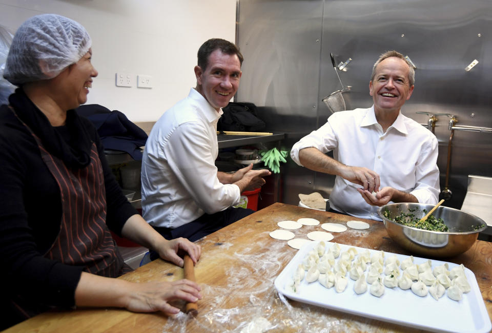 Australian Labour Party leader Bill Shorten, right, and local Labor candidate Sam Crosby, center, make dumplings during a visit to a Chinese restaurant in Sydney, Thursday, May 16, 2019. A federal election will be held in Australian on Saturday May 18, 2019. (Lukas Coch/AAP Image via AP)