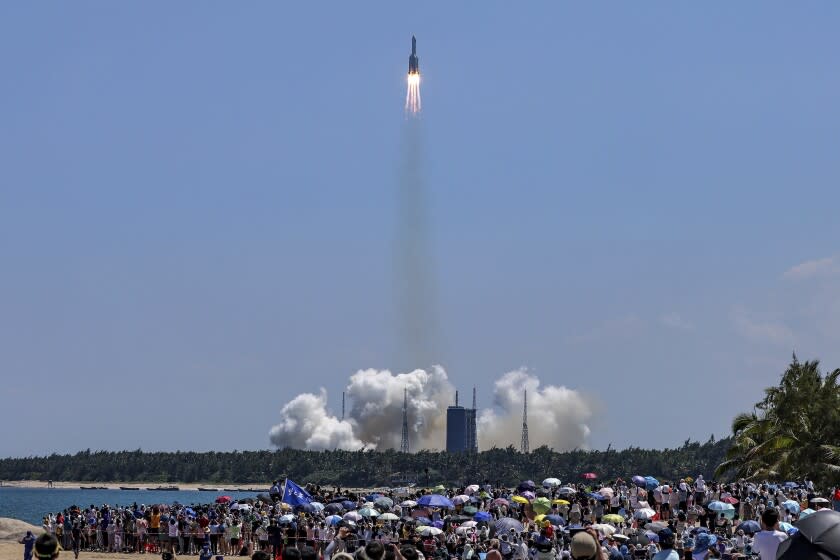 FILE - In this photo released by Xinhua News Agency, people gather at the beach side as they watch the Long March 5B Y3 carrier rocket, carrying Wentian lab module, lift off from the Wenchang Space Launch Center in Wenchang in southern China's Hainan Province Sunday, July 24, 2022. There was no reported damage in a western Philippine region, where debris from a rocket that boosted part of China's new space station reportedly fell, a Filipino official said Monday, Aug. 1. (Zhang Liyun/Xinhua via AP, File)