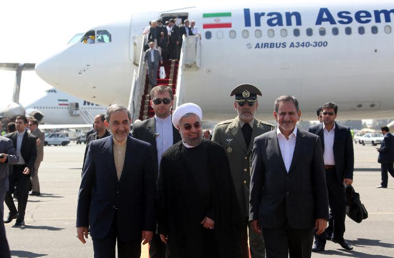 Iranian president Hassan Rouhani (C), Ali Akbar Velayati (L) advisor to the Islamic republic's supreme leader Ayatollah Ali Khamenei and Eshaq Jahangiri (R) the First Vice President arrive at Tehran's Mehrabad Airport, on September 28, 2013