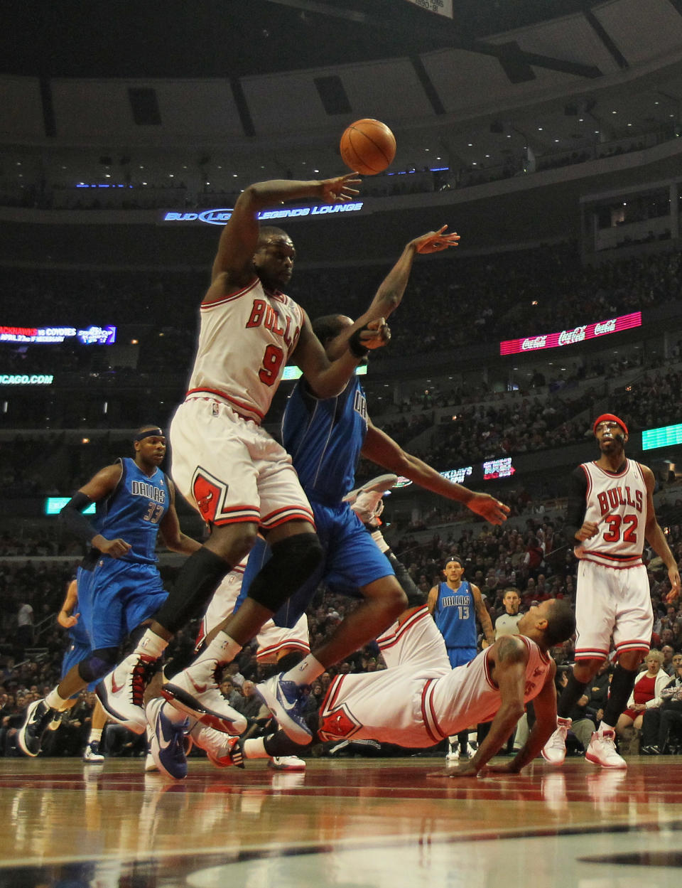 CHICAGO, IL - APRIL 21: Derrick Rose #1 of the Chicago Bulls hits the floor after being fouled by Rodrigue Beaubois #3 of the Dallas Mavericks as Loul Deng #9 defends at the United Center on April 21, 2012 in Chicago, Illinois. NOTE TO USER: User expressly acknowledges and agress that, by downloading and/or using this photograph, User is consenting to the terms and conditions of the Getty Images License Agreement. (Photo by Jonathan Daniel/Getty Images)