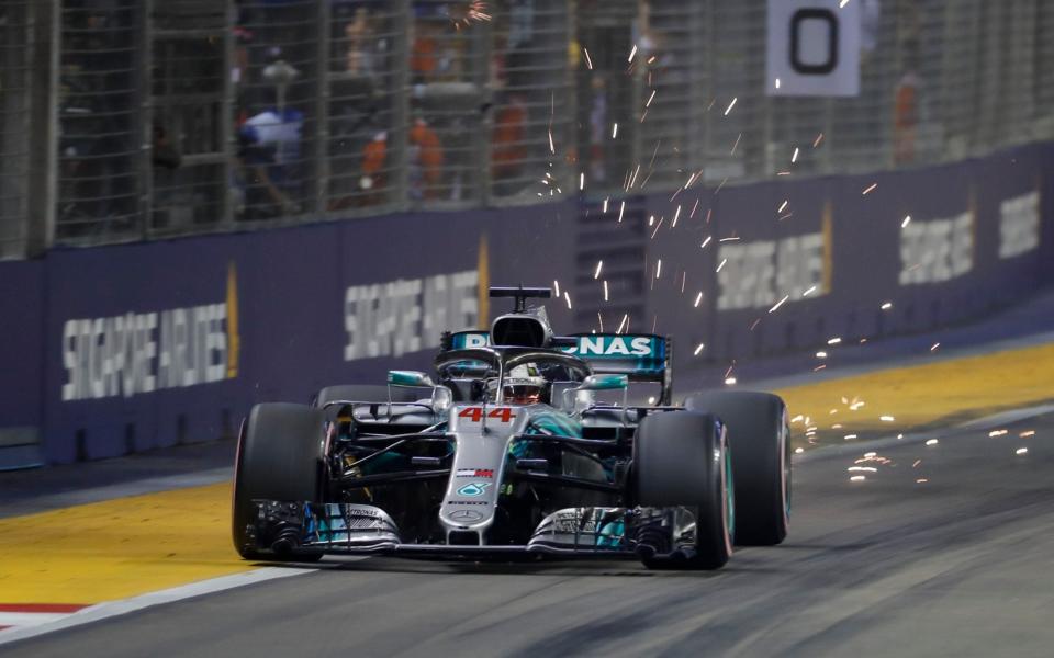 Sparks fly from the rear Mercedes driver Lewis Hamilton of Britain during qualifying at the Marina Bay City Circuit ahead of the Singapore Formula One Grand Prix in Singapore, Saturday, Sept. 15, 2018 - AP/Vincent Thian 