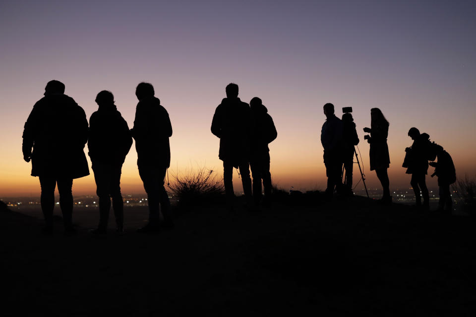 Journalists and observers wait for the arrival of an Air Canada Boeing 767 aircraft landing at the Adolfo Suárez-Barajas international airport in Barajas, outskirts of Madrid, Monday, Feb. 2, 2020. An Air Canada Boeing 767 aircraft with 128 passengers on board is flying in circles near Madrid trying to discard fuel as it prepares for an emergency landing on Monday following problems with one of the two engines and a ruptured tire during take-off. (AP Photo/Bernat Armangue)