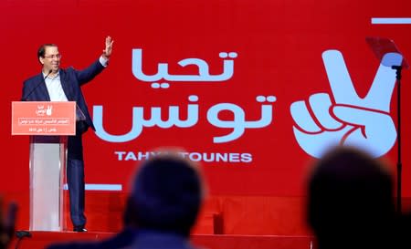 Tunisian Prime Minister Youssef Chahed waves during a meeting of the 'Long Live Tunisia' party in Tunis