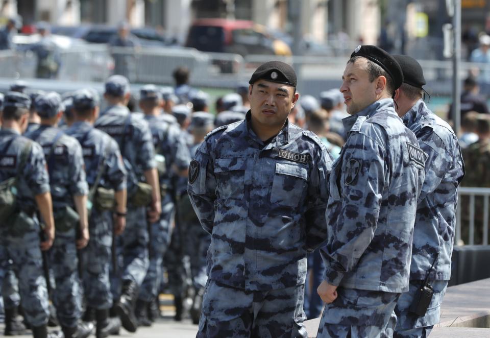 Russian policemen prepare to block a street prior to an unsanctioned rally in the center of Moscow, Russia, Saturday, July 27, 2019. Police have established a heavy presence at the Moscow mayor's office ahead of an expected protest rally and several opposition figures have been detained.(Pavel Golovkin)