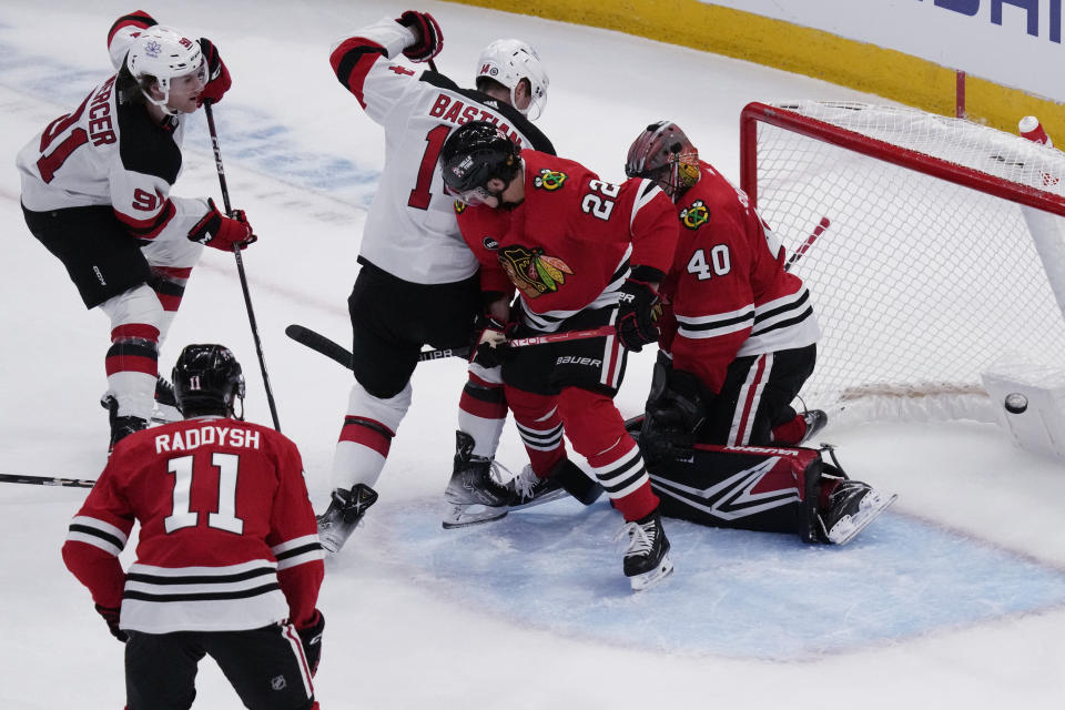 New Jersey Devils center Dawson Mercer, top left, scores against Chicago Blackhawks goaltender Arvid Soderblom (40) during the first period of an NHL hockey game in Chicago, Sunday, Nov. 5, 2023. (AP Photo/Nam Y. Huh)