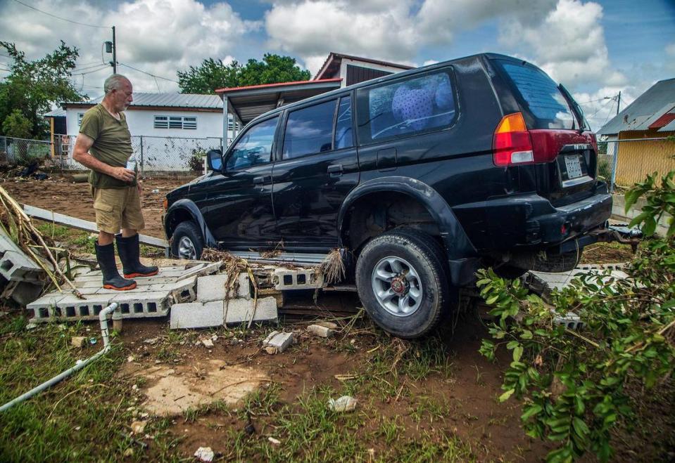 Deogracio Arce revisa su SUV que fue arrastrado más de quinientos pies hasta el patio de unos vecinos después de que el huracán Fiona inundara Villa Esperanza en Salinas, Puerto Rico, el viernes 23 de septiembre de 2022.