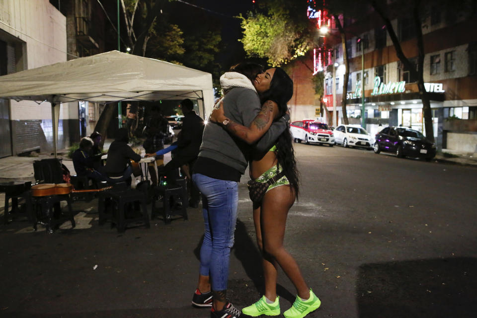 In this Aug. 28, 2019 photo, trans rights activist Kenya Cuevas embraces Angie, a 20-year-old transgender sex worker, in Mexico City. Cuevas founded the organization Casa de Muñecas, Spanish for "house of dolls," which pushes for protections for trans women. (AP Photo/Ginnette Riquelme)
