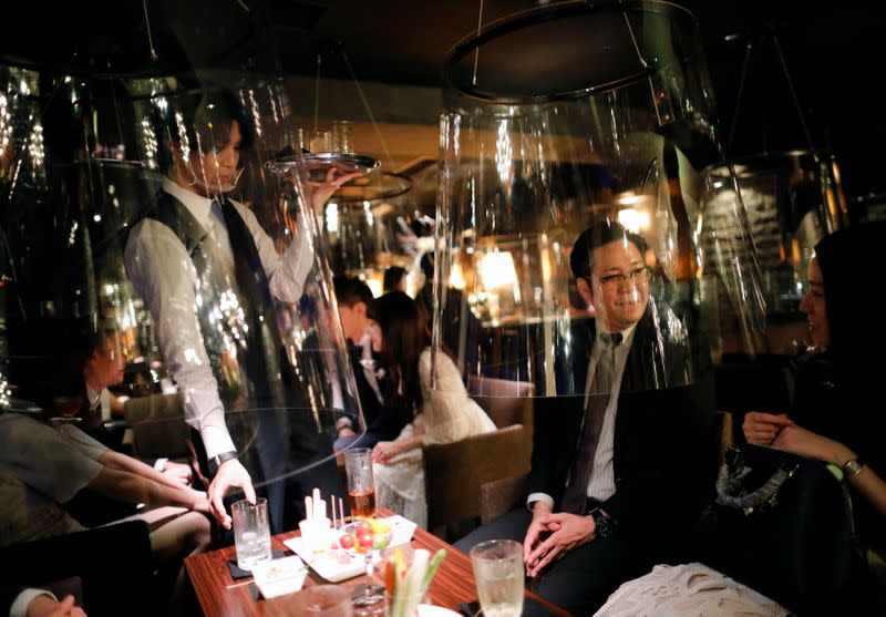 Goldfish bowl-like acrylic screens are seen installed as part of new social distancing measures and prevention of infection against the coronavirus disease (COVID-19), are installed at a night club in Tokyo