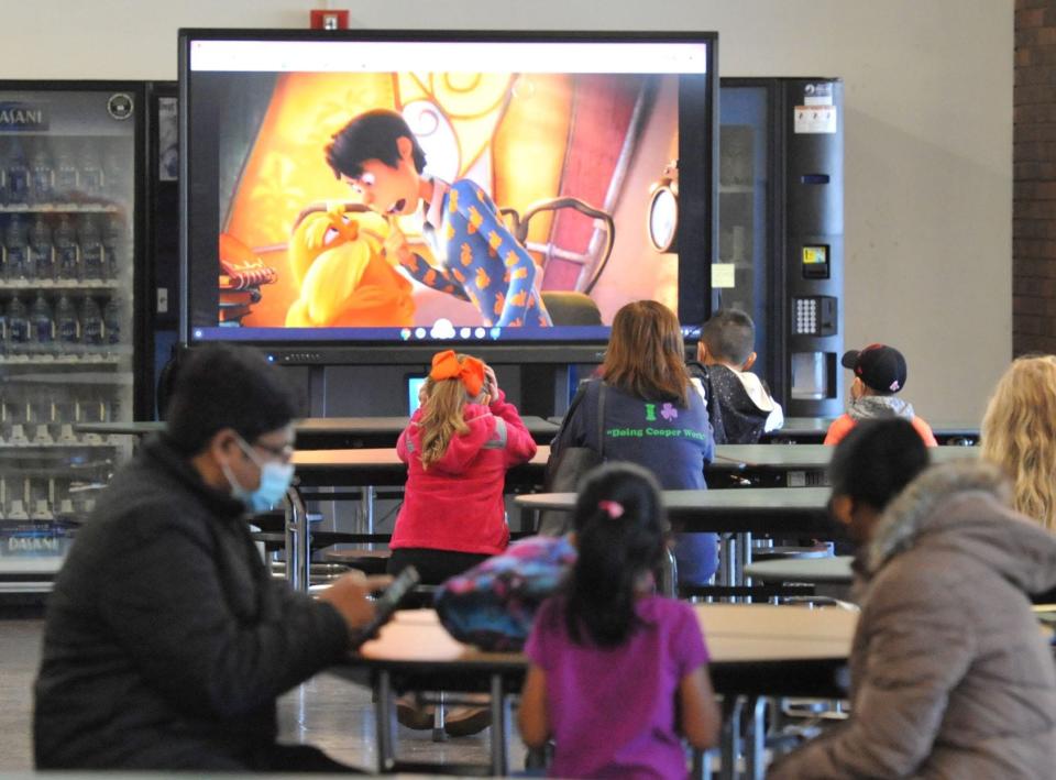 After receiving their COVID-19 vaccine, children join their parents to watch a movie during the COVID-19 student vaccination clinic at Weymouth High School on Saturday, Nov. 20, 2021.