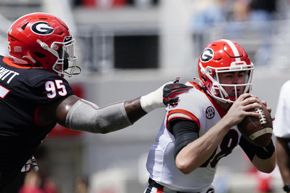 Georgia quarterback JT Daniels (18) is stopped by defensive tackle Devonte Wyatt (95) during their spring NCAA college football game, Saturday, April 17, 2021, in Athens, Ga. (AP Photo/John Bazemore)