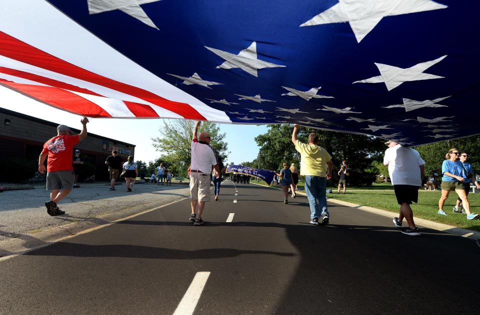 Members of Elks Lodge #158 of Springfield carry the American flag through Lincoln Park during the Illinois State Fair Twilight Parade Thursday, August 10, 2023. The parade stepped off from the park, went down Sangamon Avenue and through the Main Gate.