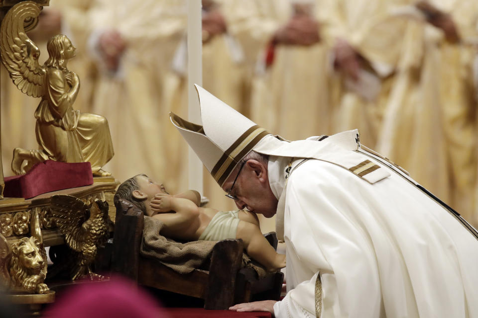 Pope Francis kisses a statue of Baby Jesus as he celebrates the Christmas Eve Mass in St. Peter's Basilica at the Vatican, Monday, Dec. 24, 2018. (AP Photo/Alessandra Tarantino)