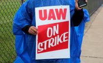 Member of United Auto Workers, Aramark workers, carries a strike sign outside the General Motors Detroit-Hamtramck assembly plant in Detroit