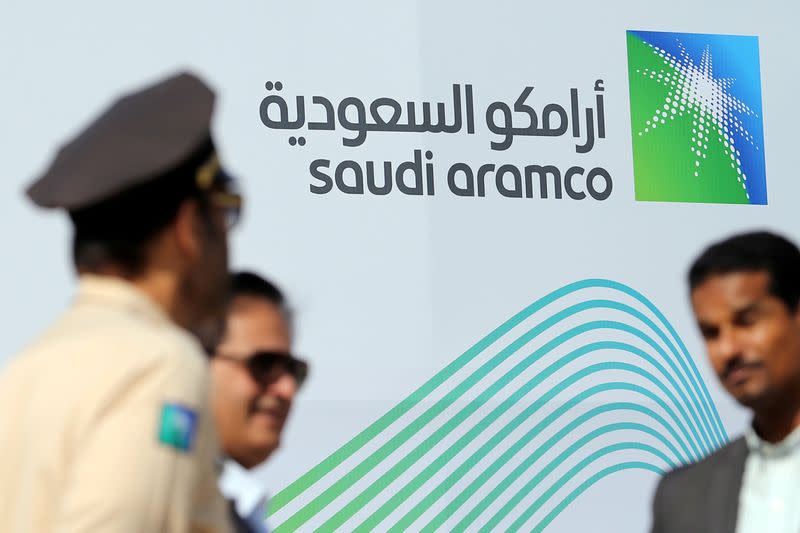 FILE PHOTO: Logo of Aramco is seen as security personnel stand before the start of a press conference by Aramco at the Plaza Conference Center in Dhahran