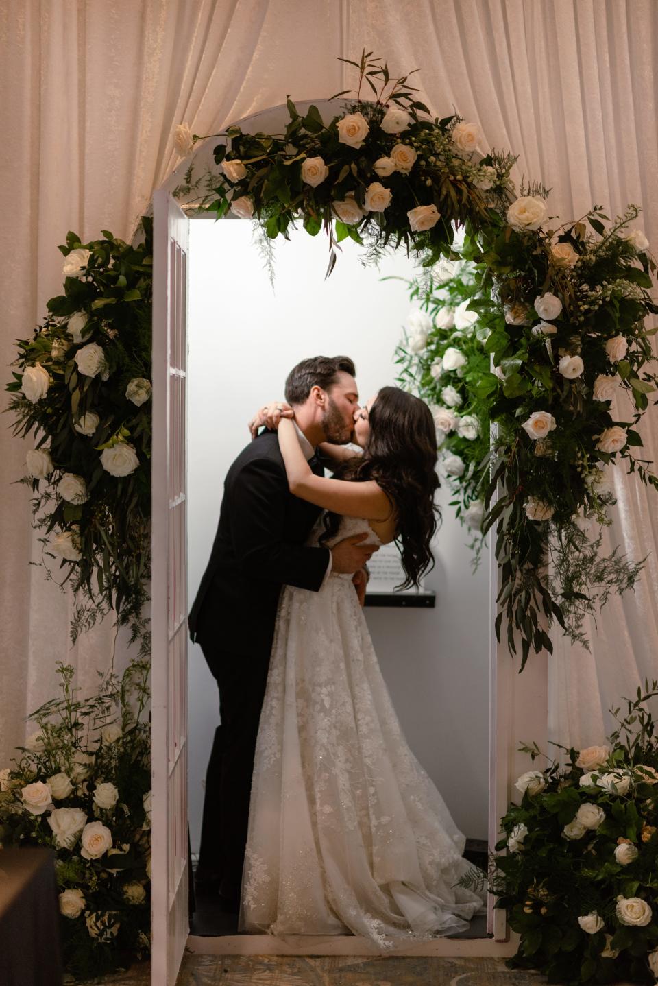 Mitchell and Nicole Cooper kiss for the camera during their wedding in June in Palm Beach Gardens.