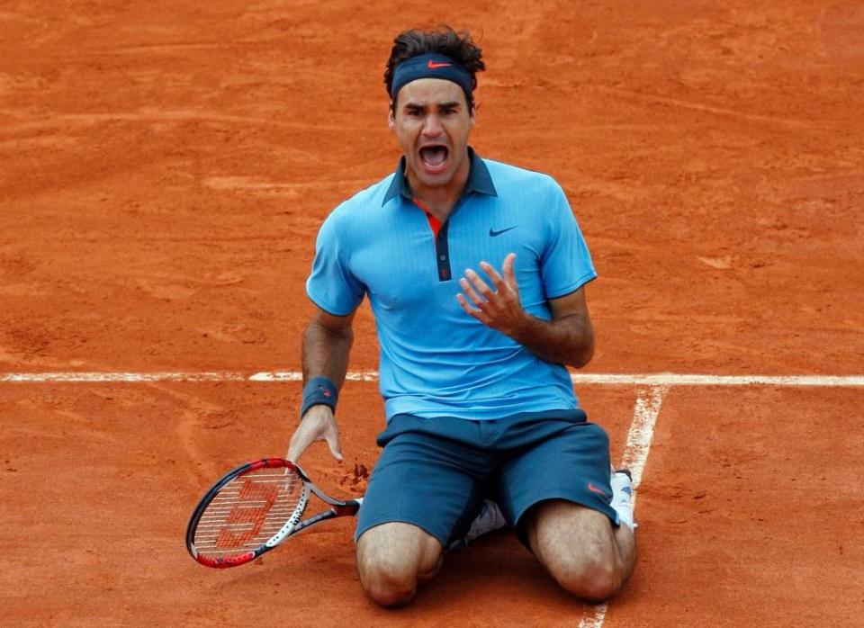 Roger Federer celebrates winning his only French Open title in 2009 to complete his career grand slam.