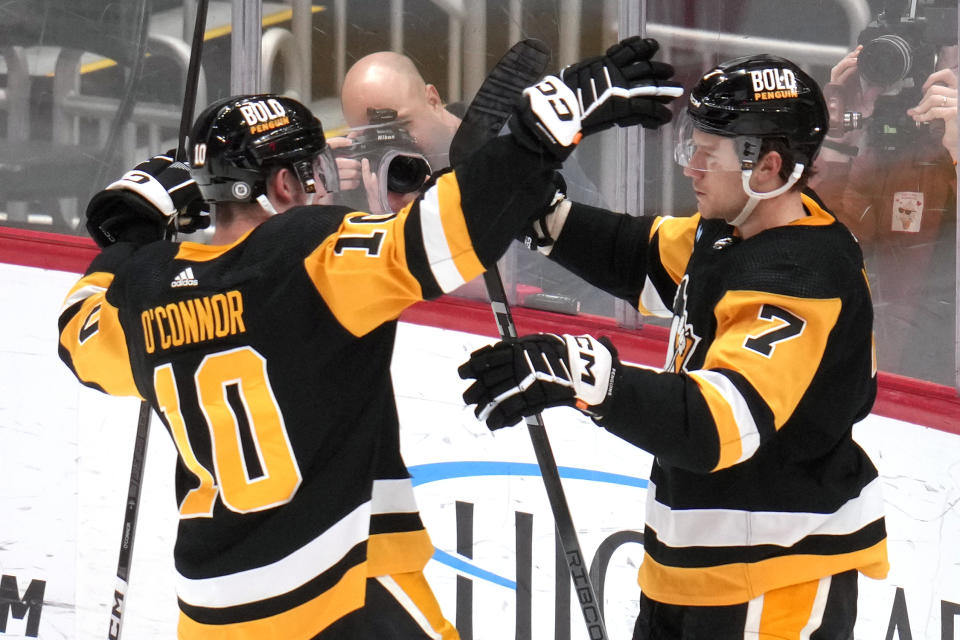 Pittsburgh Penguins' John Ludvig (7) celebrates with Drew O'Connor after scoring his first NHL goal during the third period of an NHL hockey game against the Florida Panthers in Pittsburgh, Wednesday, Feb. 14, 2024. The Panthers won 5-2. (AP Photo/Gene J. Puskar)