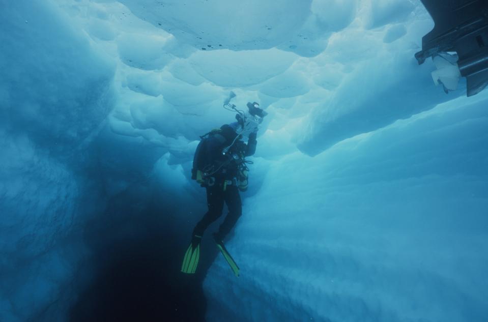 A scuba diver floating in an ice cave