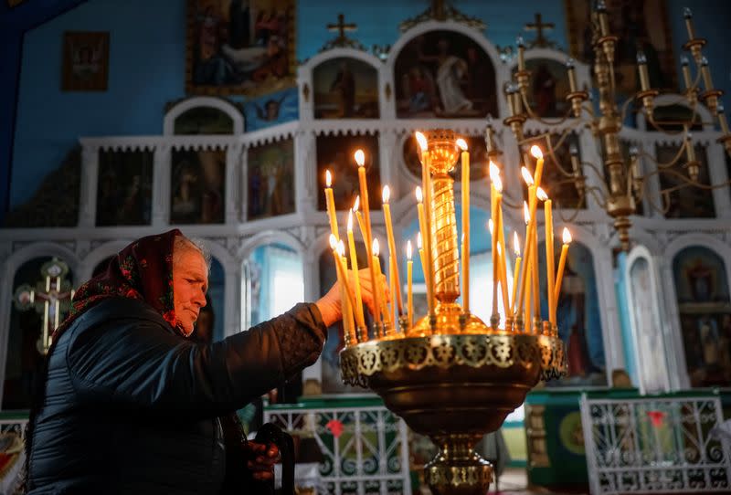 A woman pleases a candle before a service in the church, which switched from the Ukrainian Orthodox Church to the Orthodox Church of Ukraine in the village of Hrabivtsi