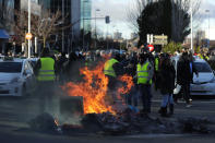 <p>Los taxistas queman contenedores de basura en las cercanías de IFEMA para impedir el paso de los vehículos este 23 de enero en Madrid. (Foto: Manu Fernández / AP). </p>