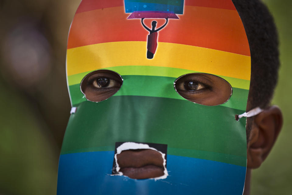 A person wears a mask as Kenyan gays and lesbians and others supporting their cause wear masks to preserve their anonymity as they stage a rare protest, against Uganda's increasingly tough stance against homosexuality and in solidarity with their counterparts there, outside the Uganda High Commission in Nairobi, Kenya Monday, Feb. 10, 2014. Homosexuality has been criminalized in Uganda where lawmakers have recently passed a new bill, which appears to have wide support among Ugandans, that prescribes life imprisonment for "aggravated" homosexual acts. (AP Photo/Ben Curtis)