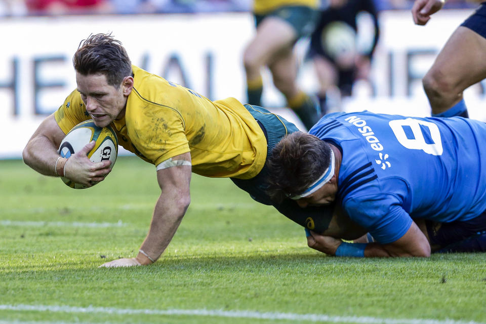 FILE - Australia's Bernard Foley, left, is tackled by Italy's Andries Van Schalkwyk before the try line during their international rugby match in Brisbane, Australia, on June 24, 2017. Foley was recalled, Tuesday Sept. 13, 2022, to the starting XV for the Bledisloe rugby match against the All Blacks in Melbourne on Sept. 15. (AP Photo/Tertius Pickard, File)