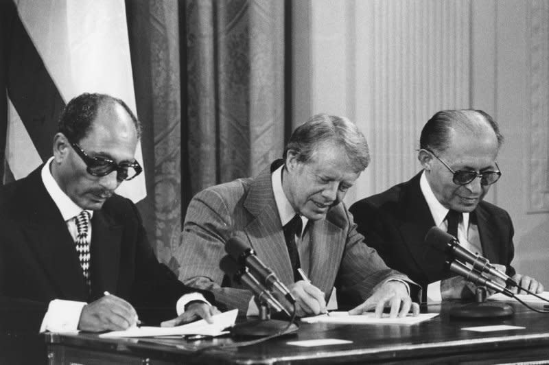 From left to right, Egyptian President Anwar Sadat. U.S. President Jimmy Carter, and Israeli Prime Minister Menachem Begin sign two agreements providing for negotiation of a full Middle East peace treaty within three months in a ceremony in the East Room of the White House on September 17, 1978. File Photo by Darryl Heikes/UPI