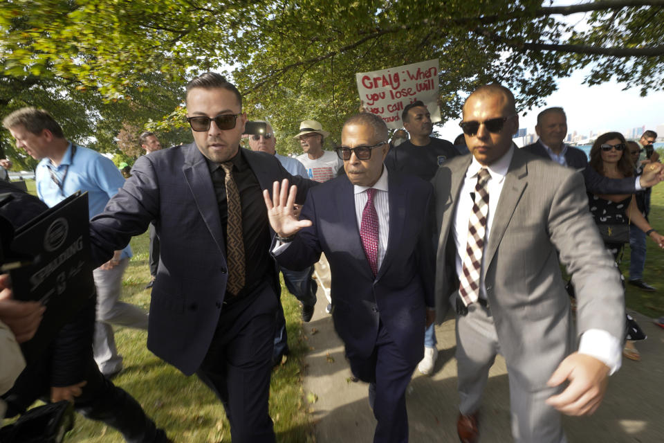 James Craig, a former Detroit Police Chief, is led from a news conference after announcing he is a Republican candidate for Governor of Michigan amongst protesters on Belle Isle in Detroit, Tuesday, Sept. 14, 2021. (AP Photo/Paul Sancya)