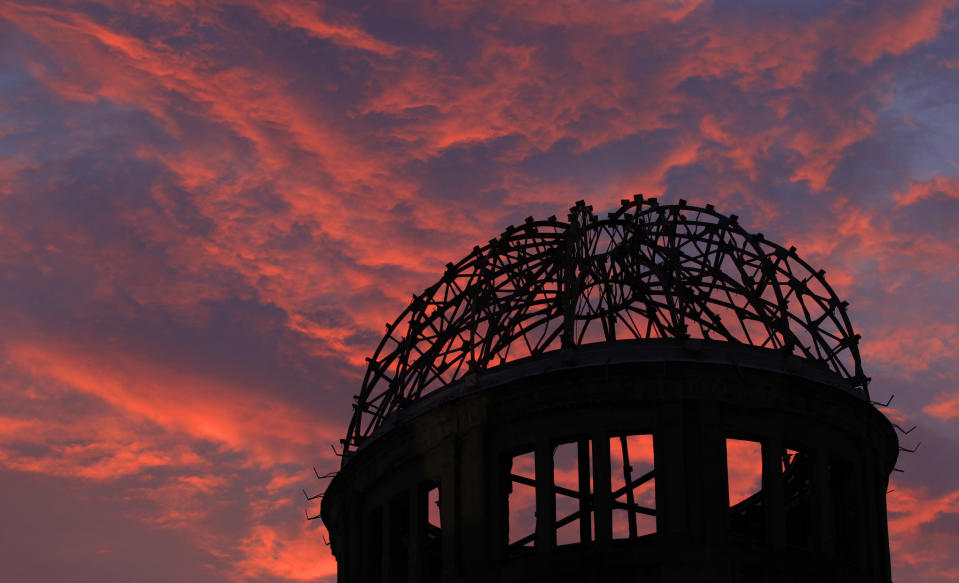 FILE - In this Aug. 5, 2013, file photo, the Atomic Bomb Dome is silhouetted at sunset in Hiroshima, western Japan. Many residents of Hiroshima welcome attention to their city from abroad, which IOC President Thomas Bach will bring when he visits on Friday, July 16. But Bach will also bring political baggage — as will his vice president John Coates when he visits Nagasaki the same day — that is largely unwelcome in two cities viewed as sacred by many Japanese. (AP Photo/Shizuo Kambayashi, File)