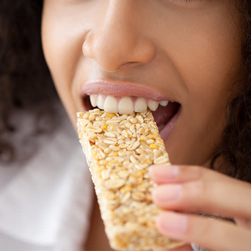 young woman eating granola bar