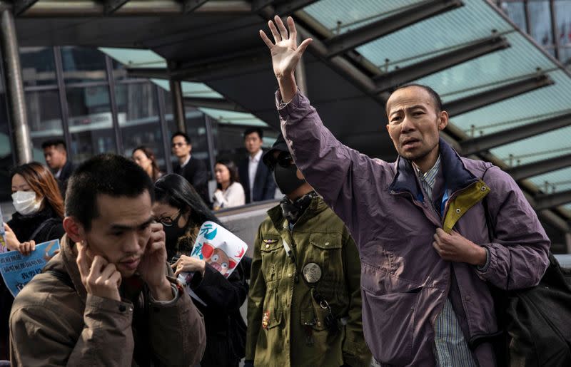 A man shouts slogans as office workers attend a lunch time protest on a pedestrain bridge in Hong Kong