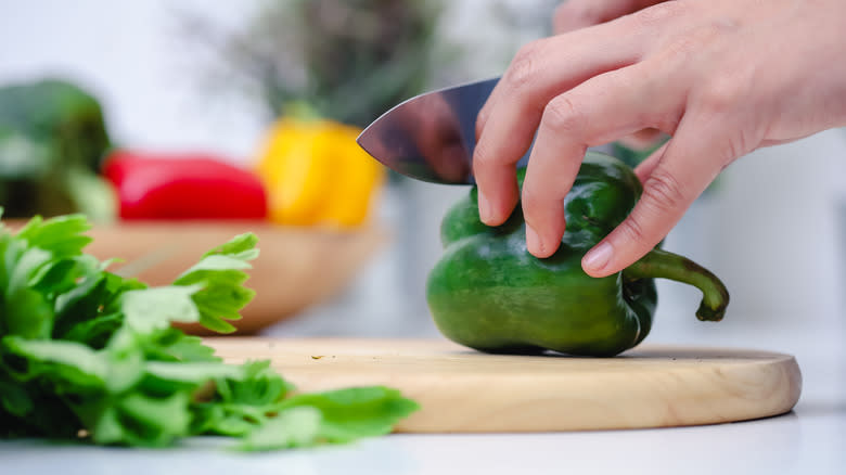 Manos cortando chiles verdes