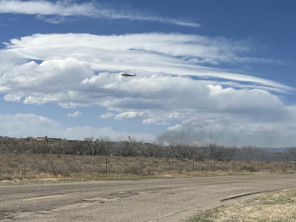 A helicopter aids in firefighting operations for the Vision Hills Fire, which had burned over 100 acres and prompted 25 evacuations as of Friday afternoon.