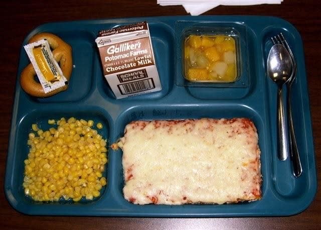 old school lunch with square pizza, corn, fruit, and chocolate milk