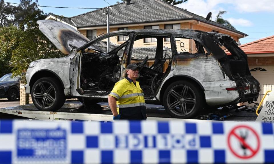 A burnt-out vehicle is removed 