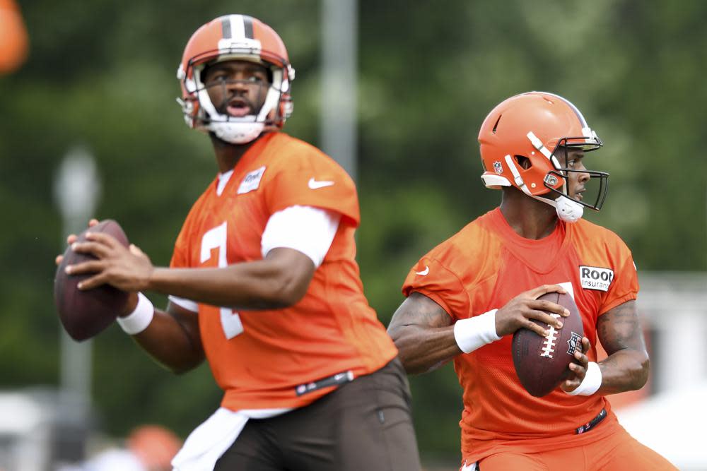 Cleveland Browns quarterbacks Deshaun Watson, right, and Jacoby Brissett look to pass during the NFL football team’s training camp, Monday, Aug. 1, 2022, in Berea, Ohio. (AP Photo/Nick Cammett)