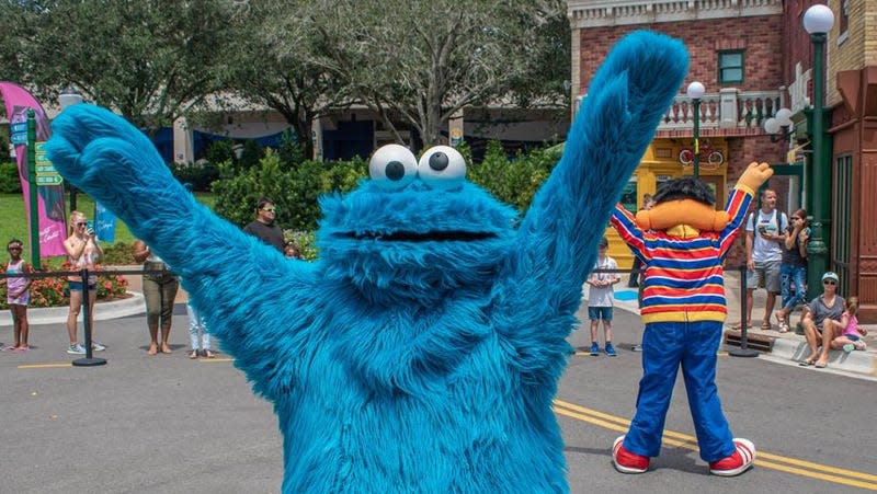 A man wearing a Cookie Monster costume at a theme park