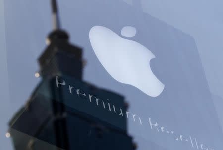 The Apple logo is seen against the reflection of Taiwan's landmark building Taipei 101, August 25, 2011. REUTERS/Pichi Chuang