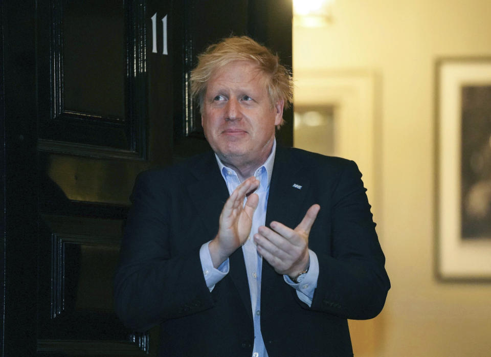 FILE - In this Thursday, April 2, 2020 handout photo provided by 10 Downing Street, Britain's Prime Minister Boris Johnson claps outside 11 Downing Street to salute local heroes during Thursday's nationwide Clap for Carers NHS initiative to applaud workers fighting the coronavirus pandemic, in London. Johnson has been moved to the intensive care unit of a London hospital on Monday, April 6, 2020 after his coronavirus symptoms worsened. Johnson’s office says Johnson is conscious and does not require ventilation at the moment. Johnson was admitted to St. Thomas’ Hospital late Sunday, 10 days after he was diagnosed with COVID-19. (Pippa Fowles/10 Downing Street via AP, File)